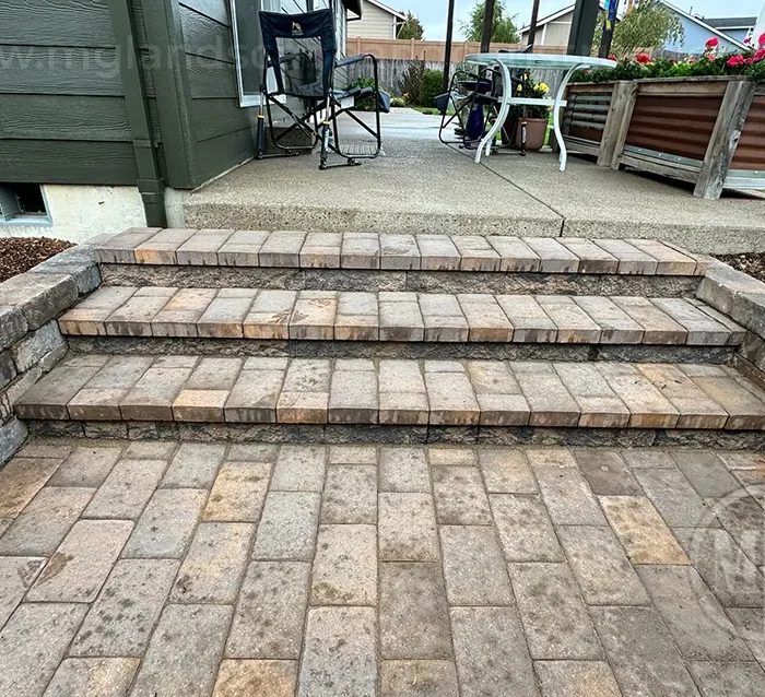 Paver steps connecting a lower patio to a raised outdoor seating area