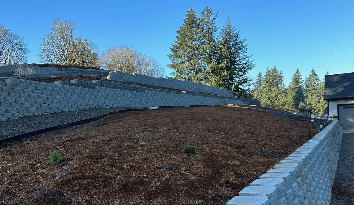 Block retaining walls forming terraces across a sloped residential landscape