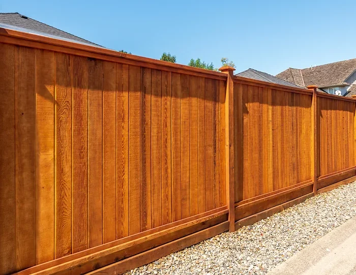 Wood privacy fence with capped posts along a residential property