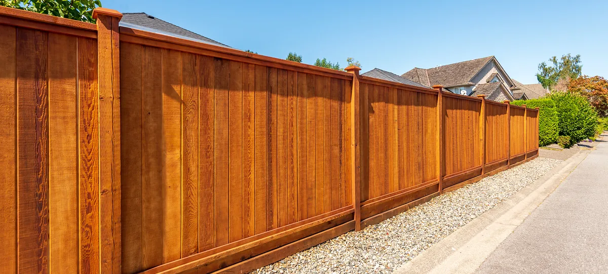 Wood privacy fence with capped posts along a residential property